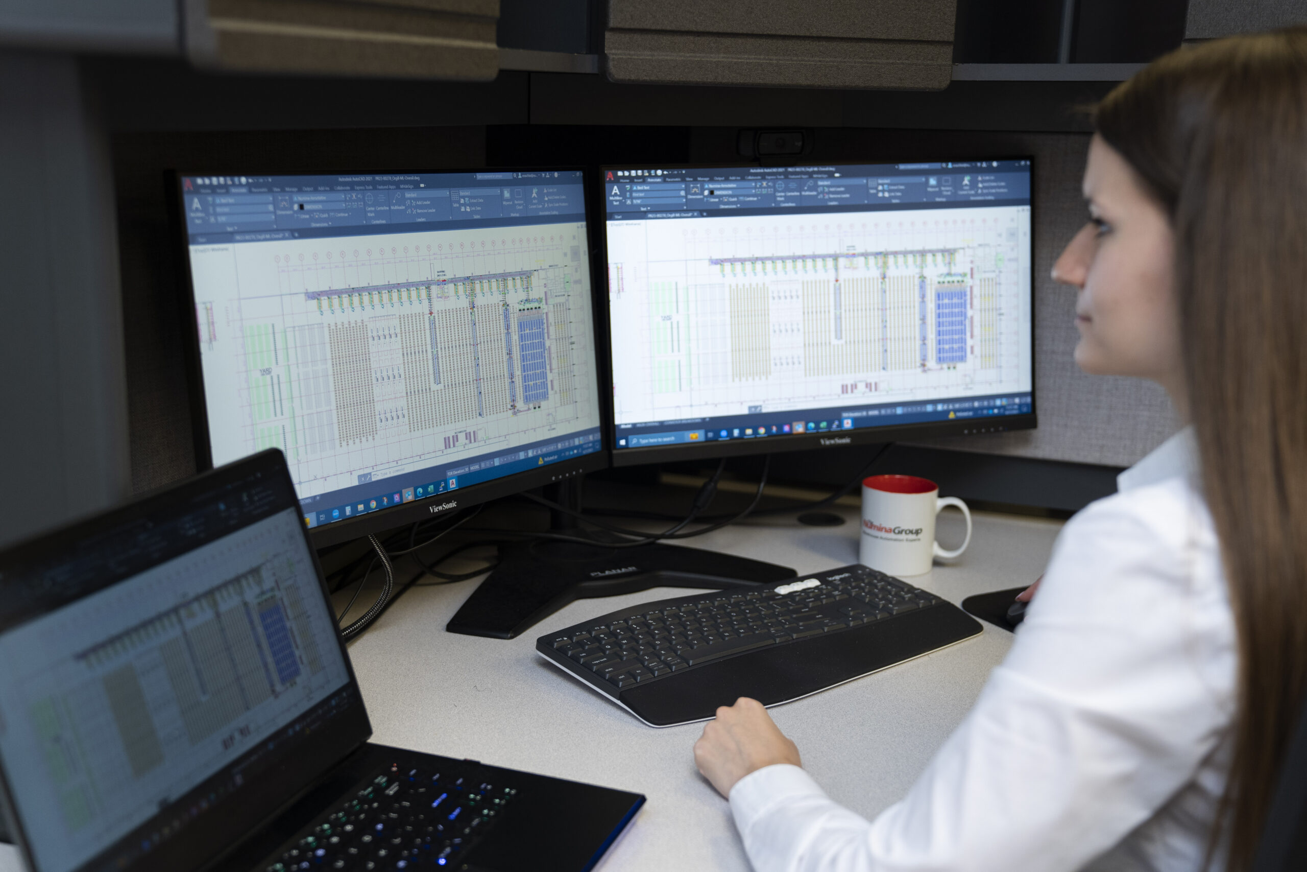 A Numina Group engineer developing a warehouse layout in AutoCAD on dual monitors.